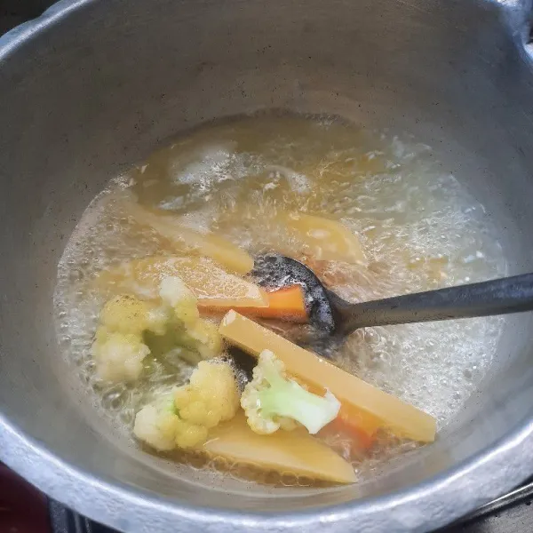 Rebus kondimen pendamping seperti kentang wortel dan kembang kol sampai matang.