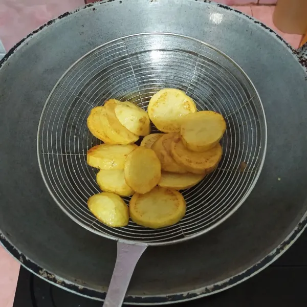 Kupas kentang, lalu goreng hingga matang.