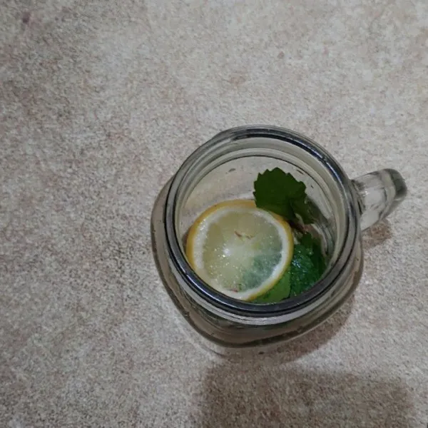 Dalam gelas masukan daun mint dan potong jeruk lemon.