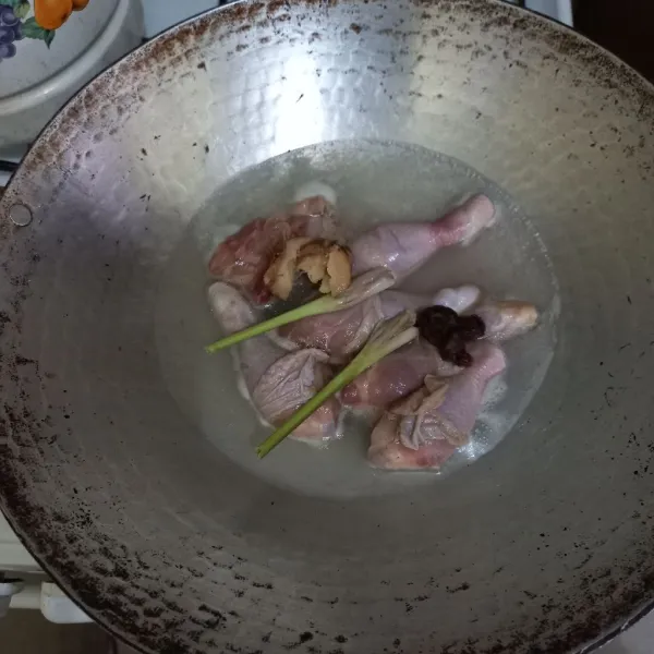 Didihkan air, masukkan potongan ayam, lengkuas dan asam jawa.