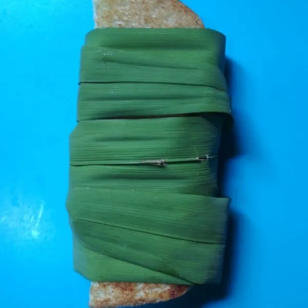 Balut roti tawar dengan daun pandan.