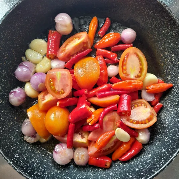 Kemudian masukkan potongan cabai merah besar, cabai merah keriting, cabai rawit merah dan tomat. Aduk rata dan masak hingga semua layu, angkat.
