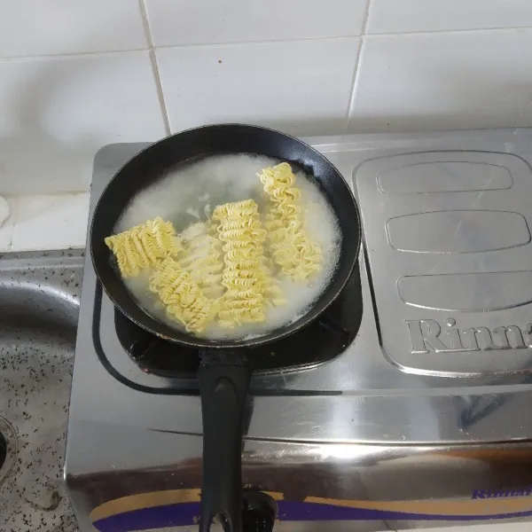 Rebus mie dalam air mendidih.