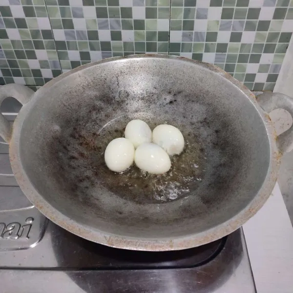 Goreng telur dalam minyak panas hingga berkulit. Lalu angkat dan tiriskan.