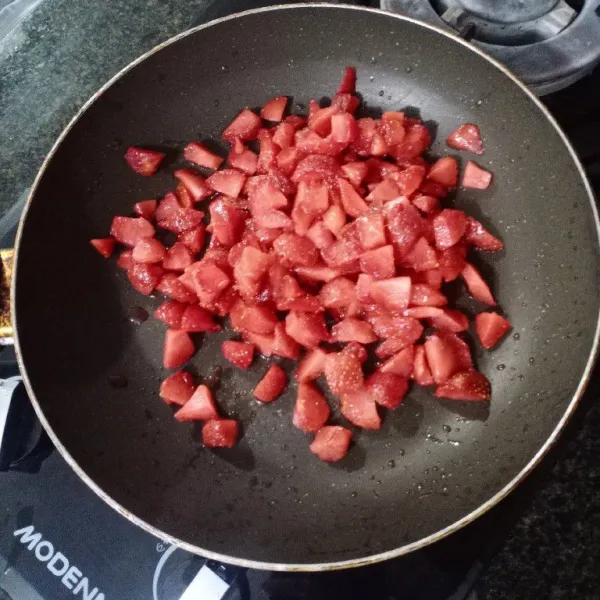 Potong-potong kecil strawberry. Masak di atas api kecil.