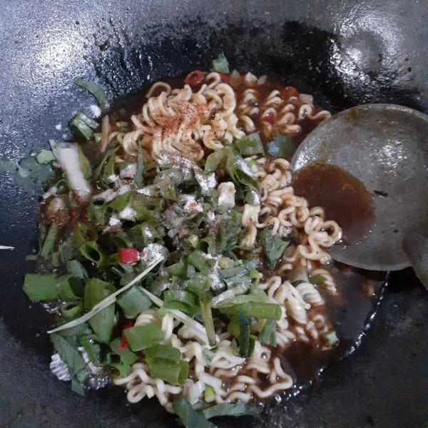 Masukkan mie beserta bumbu, minyak serta kecapnya, tambahkan juga irisan daun bawang dan cincangan seledri, aduk rata dan masak hingga mie matang. Sajikan indomie goreng lada hitam bersama bahan pelengkapnya!