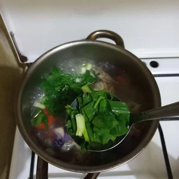 Tambahkan irisan bawang daun dan seledri, masak hingga matang.