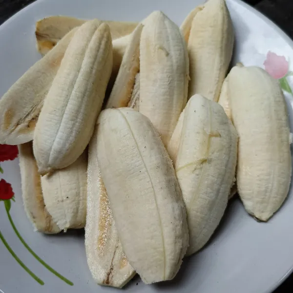 Kupas pisang dan belah dua tidak putus