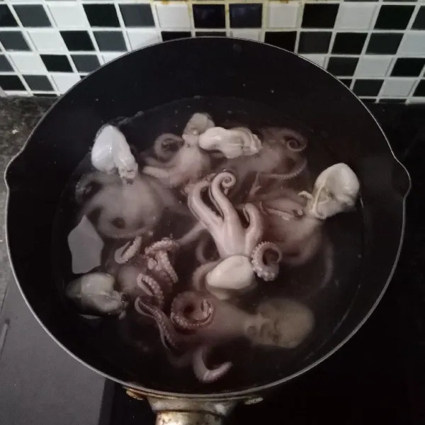 Didihkan air yang ditambahkan baking soda. Masukkan baby octopus. Rebus sampai tidak alot.