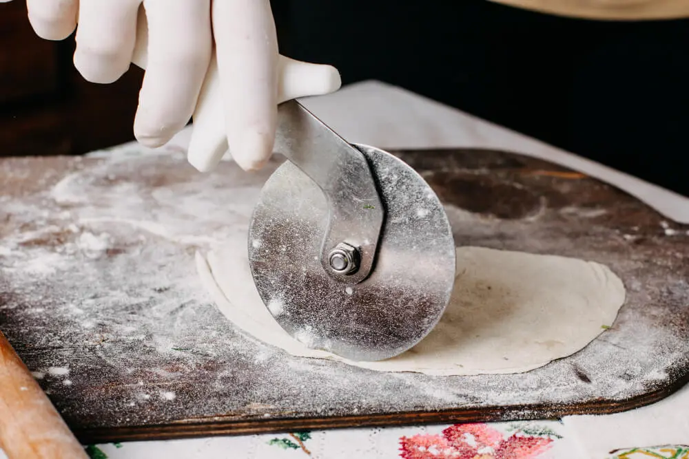 memotong adonan dengan pastry wheel