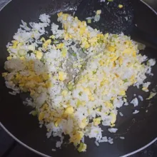 Masukkan nasi putih, aduk. Beri lada bubuk. Aduk rata.