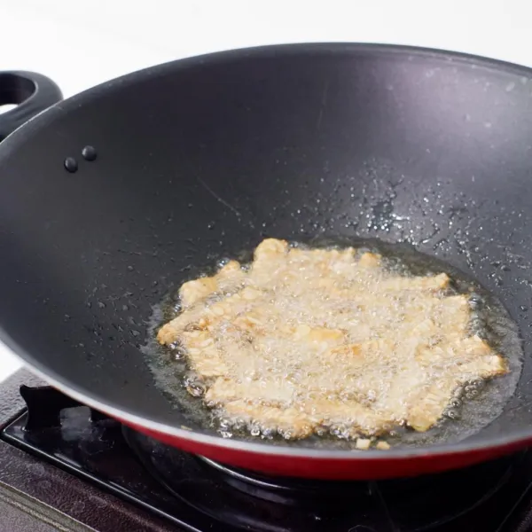 Masukkan 400 ml minyak goreng ke wajan. Goreng tempe yang sudah dipotong-potong hingga setengah matang. Angkat dan tiriskan.