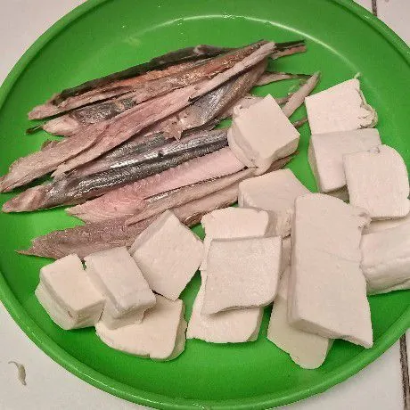 Siapkan dulu bahan utamanya. Bersihkan ikan tuna asap, buang duri kepala dan siripnya. Tahu dipotong-potong kecil.