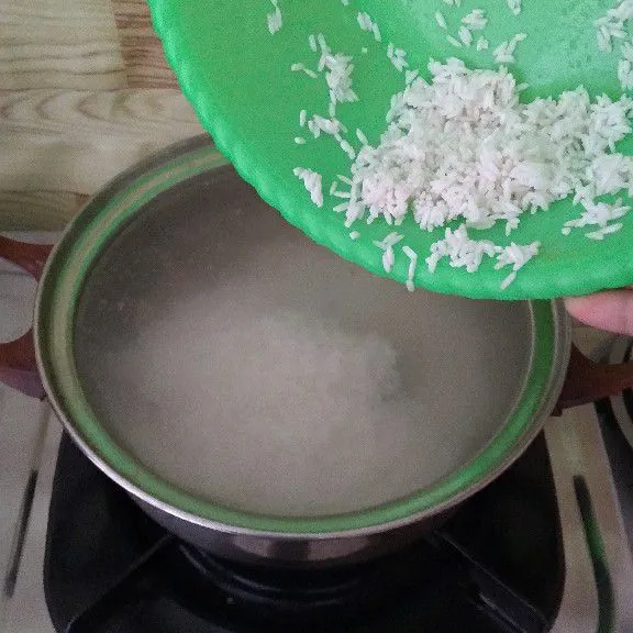Masukkan beras lalu aduk. Ambil daging ayam jika beras mulai empuk.