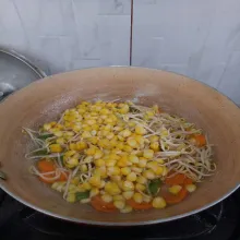 Masukkan tauge dan jagung rebus, aduk rata lalu tutup kembali dan masak selama 3 menit.