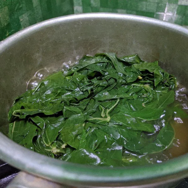 Rebus daun singkong dalam air mendidih dengan tambahan sedikit garam. Rebus hingga daun singkong empuk.