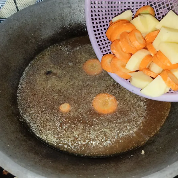 Setelah mendidih, masukkan kentang dan wortel, masak sampai empuk.
