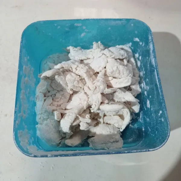 Masukkan tepung bumbu kering ke toples, masukkan jamur, tutup toples lalu kocok sampai jamur terbalut tepung kering.