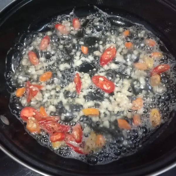 Panaskan minyak goreng, tumis bawang putih dan cabai merah sampai harum.