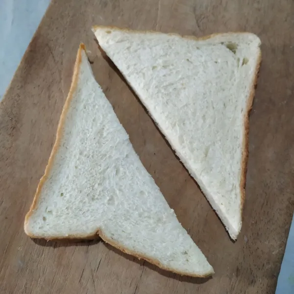 Potong roti tawar secara diagonal.