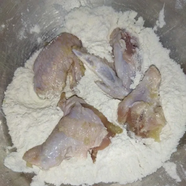 Siapkan bahan tepung pelapis kering, aduk rata, lalu lapisi sayap ayam dengan tepung pelapis kering.