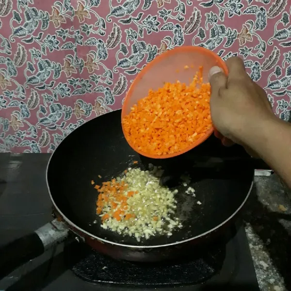 Tumis bawang putih hingga harum lalu masukkan wortel dan tambahkan sedikit air. Masak hingga wortel empuk.