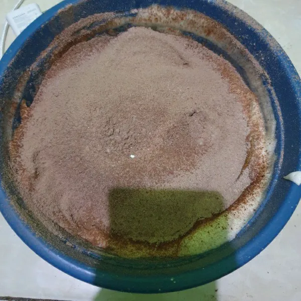 Masukkan tepung terigu, coklat bubuk dan baking powder sambil diayak, aduk rata dan sisihkan.