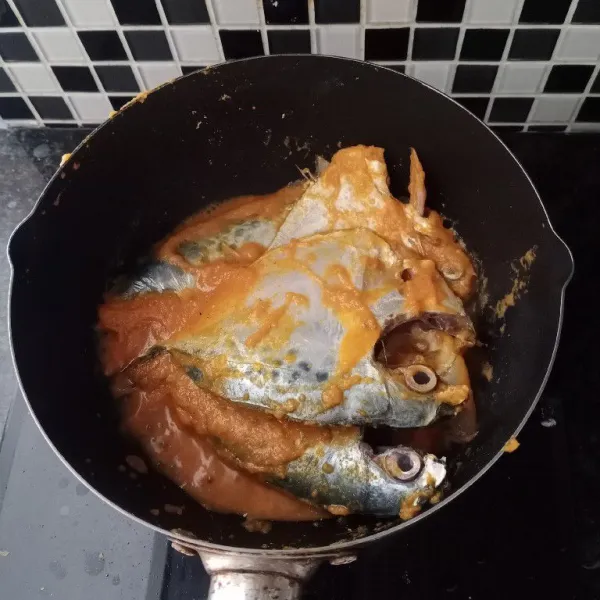 Baluri ikan dengan bumbu halus. Hidupkan api.