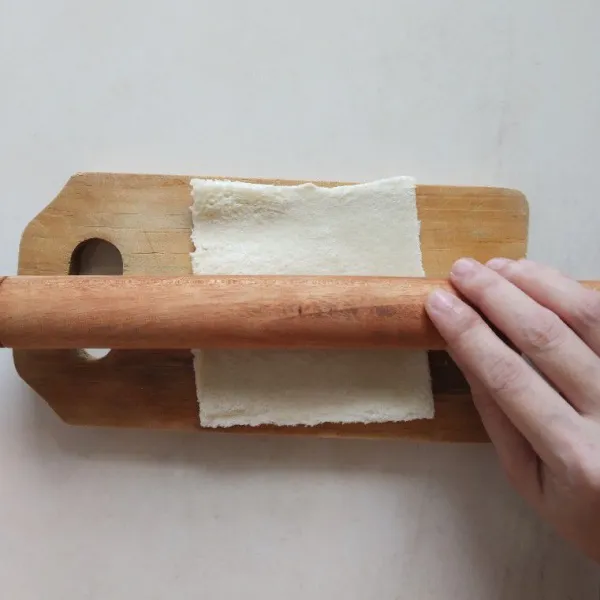 Siapkan roti dan pipihkan menggunakan rolling pin.