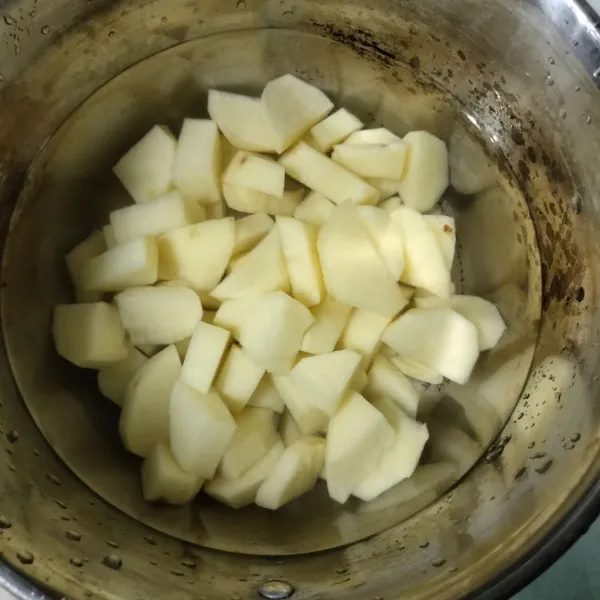 Langkah pertama, kupas kentang lalu rebus hingga matang.
