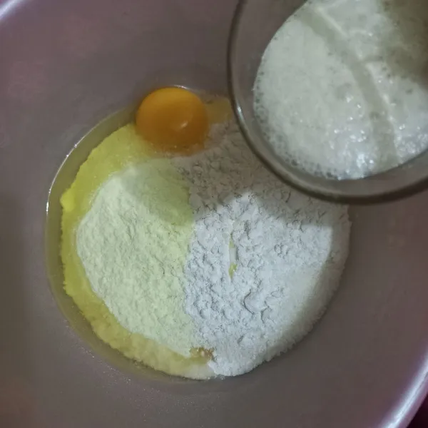 Dalam wadah campur tepung terigu, telur ayam, susu bubuk, sisa gula pasir dan larutan ragi, uleni hingga rata.