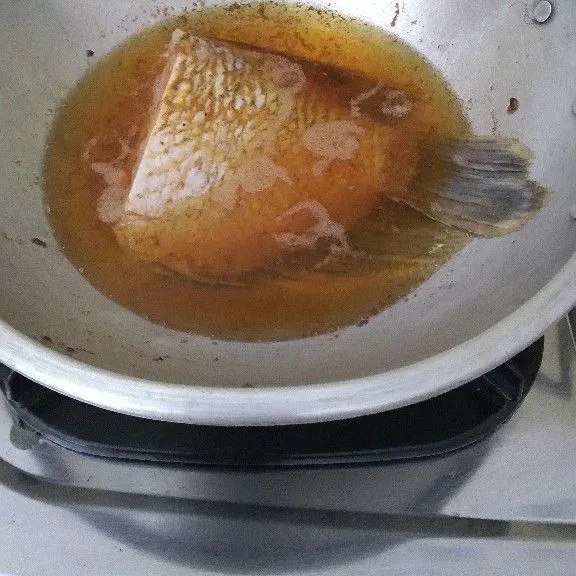 Goreng ikan ke dalam minyak panas.
