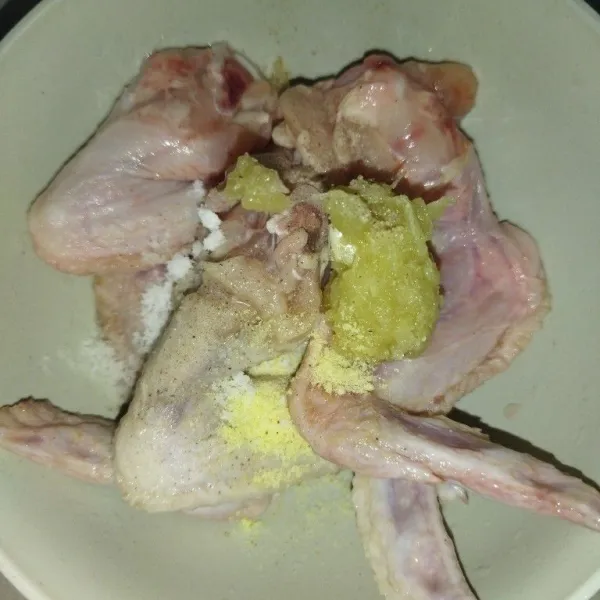 Siapkan sayap ayam yang sudah dicuci, lalu bumbui dengan bawang putih halus, garam, lada bubuk dan kaldu bubuk, aduk rata, diamkan sekitar 10 menit.