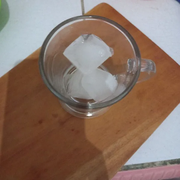 Siapkan gelas saji, masukkan es batu.