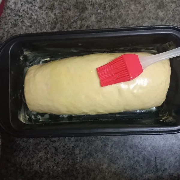 Olesi permukaan adonan roti dengan susu cair, ratakan.