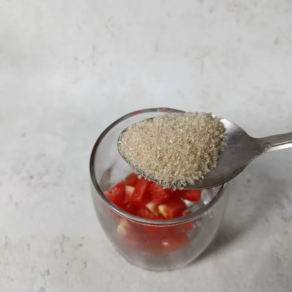 Tambahkan gula pasir dan aduk-aduk sampai gula larut dan tomat sedikit hancur.