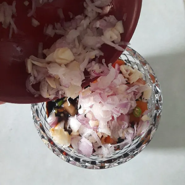 Masukan bawang merah ke dalam kecap manis yang sudah di campur dengan tomat dan cabe rawit hijau, aduk hingga tercampur.