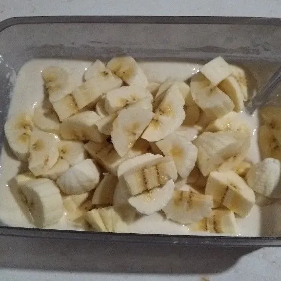 Kupas pisang dan iris tebal 1 cm. Masukkan ke dalam tepung basah. Aduk rata.