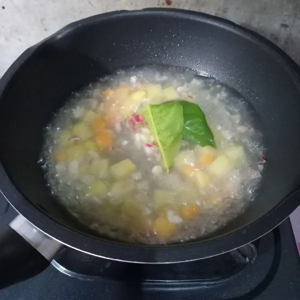 Masukkan kentang, wortel, dan daun salam. Masak sampai kentang setengah matang.