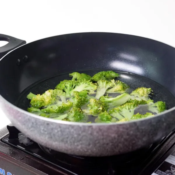 Potong kecil-kecil Brokoli dan cuci bersih. Didihkan air bersama minyak goreng. Rebus brokoli selama 5 menit. Kemudian angkat dan tiriskan.