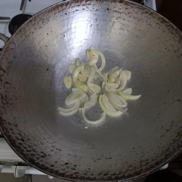 Tumis irisan bawang putih dan bawang bombay hingga harum.
