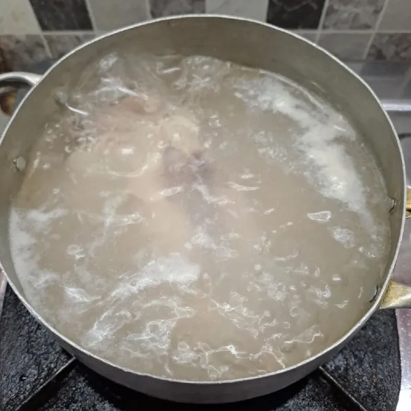 Rebus air secukupnya sampai mendidih, masukkan ayam. Masak sampai keluar buih kotorannya. Matikan kompor, buang air rebusan. Sisihkan ayam.