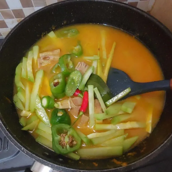 Masukkan sayur labu, nangka muda, irisan cabe gendot, dan cabe rawit utuh. Masak sampai kuah mendidih dan sayuran matang.