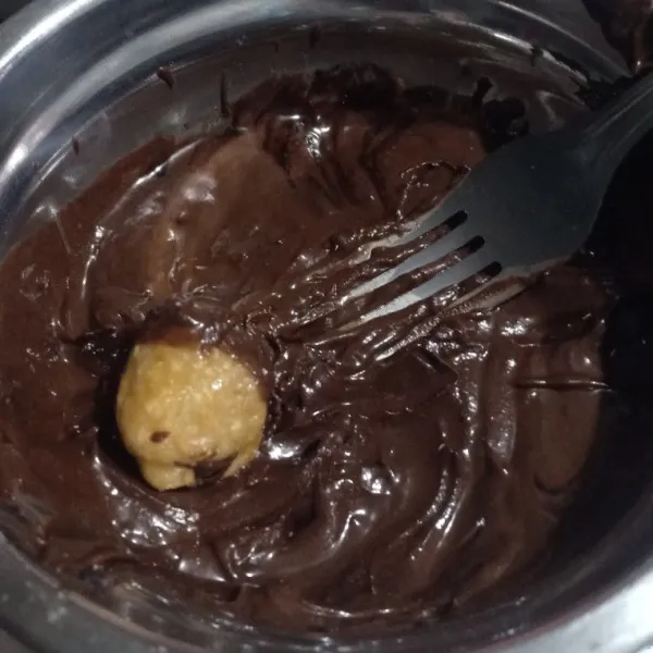 Ambil sedikit adonan, bentuk bulat lalu celupkan coklat leleh sampai rata.