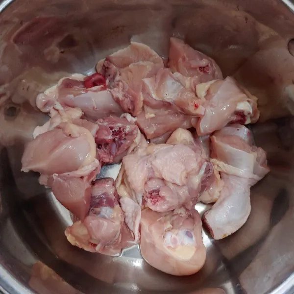 Potong daging ayam menjadi 12 bagian atau sesuai selera. Lalu masukkan daging ayam ke dalam panci.