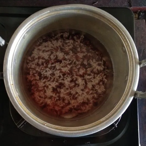 Rebus ketan hitam dan ketan putih dengan air hingga pecah dan mendidih.