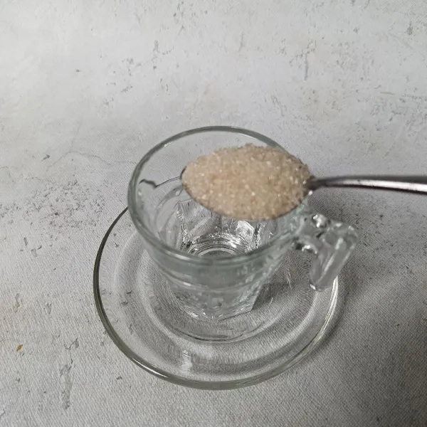 Siapkan gelas dan masukkan gula pasir.