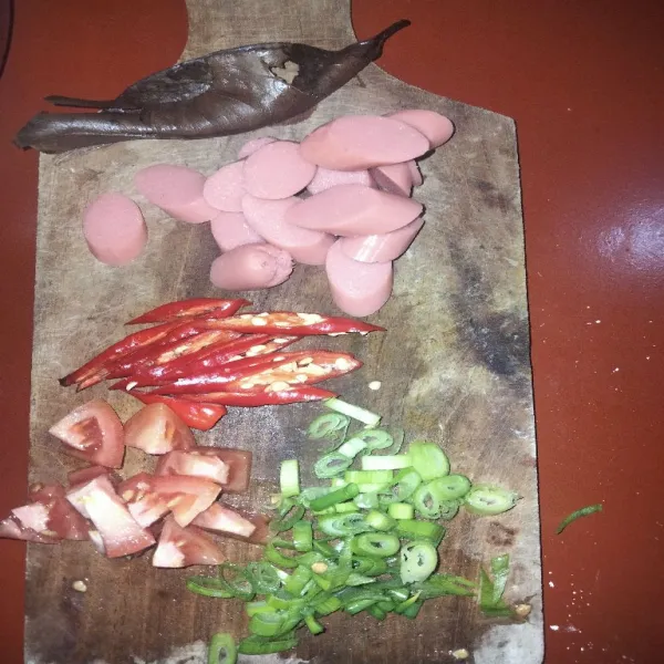 Siapkan sosis, daun salam, serta bumbu iris (diantaranya cabai merah diiris tipis menyerong, tomat merah diiris segitiga, dan daun bawang di iris timis).