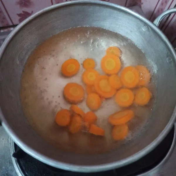 Rebus air hingga mendidih, setelah mendidih, masukkan wortel, rebus hingga setengah matang.