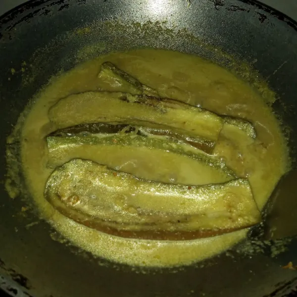 Masukkan terung rebus, tuang air asam. Masak sampai meresap. Koreksi rasa dan matikan api.